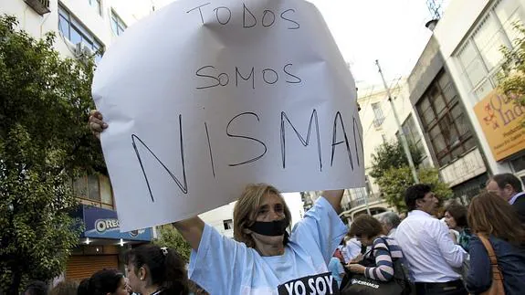Una mujer sostiene un cartel que dice "Todos somos Nisman" durante una manifestación. 
