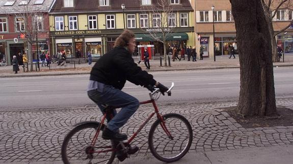 Un joven pasea en bici por una calle de Trondheim. 