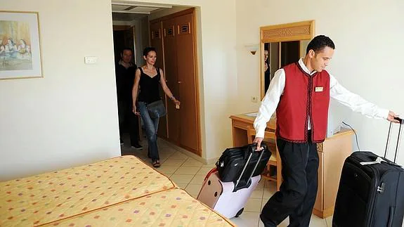 Una pareja entra en su habitación de hotel. 