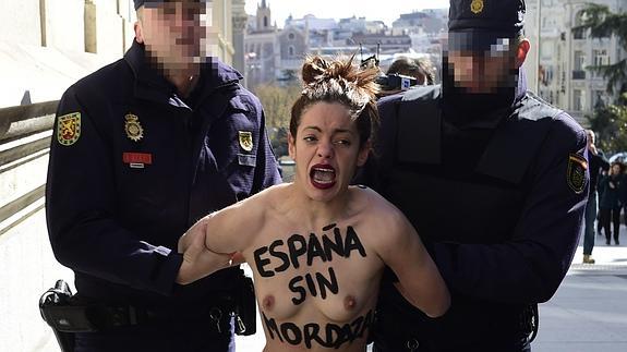 Dos agentes retienen a una activista de Femen.