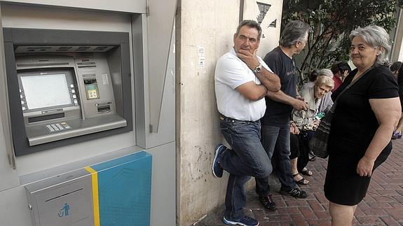 Ciudadanos griegos hacen cola en un cajero en Atenas.