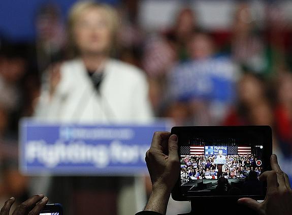 Un joven toma una imagen de Clinton anoche con su tablet. 