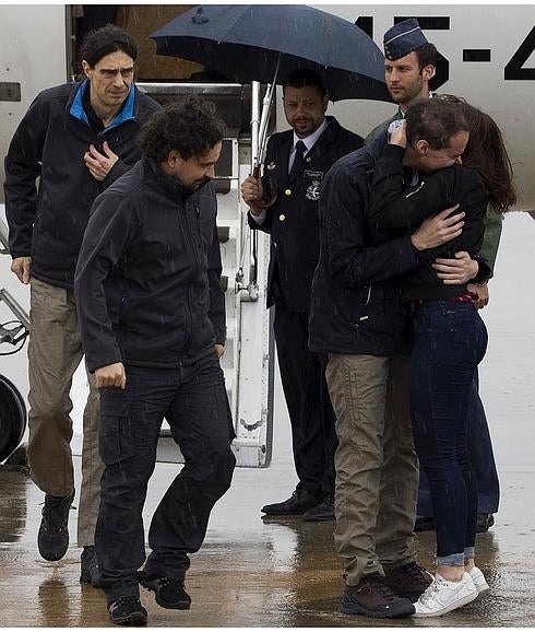 Ángel Sastre (c), José Manuel López (i) y Antonio Pampliega (d, abrazando a un familiar), a su llegada.