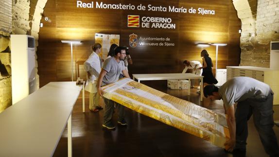 Operarios descargan una de las 53 piezas que la Generalitat ha entregado al Monasterio de Sijena.