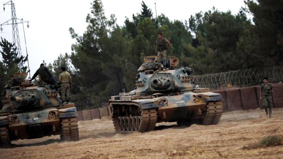 Soldados turcos montan en sus tanques antes de participar en una ofensiva contra el Estado Islámico.