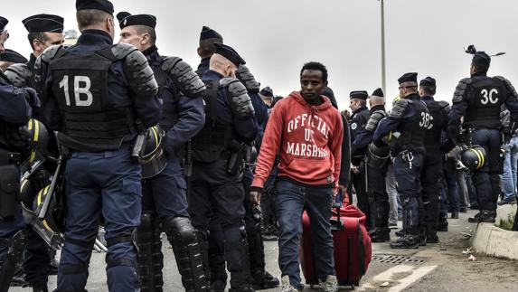 Un inmigrante se traslada con su maleta.