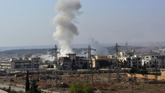 Una columna de humo se eleva durante un ataque del régimen sirio en Alepo.