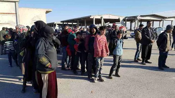 Un grupo de civiles esperan para ser evacuados de Alepo.