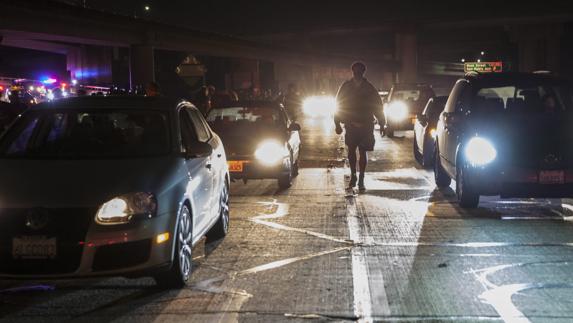 Un hombre camina entre varios coches. 