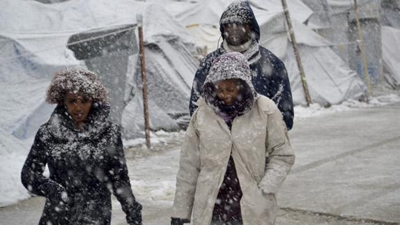 Varios refugiados caminan bajo la nieve en el campamento de refugiados de Lesbos.