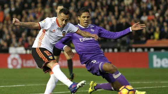 Raphael Varane (d) pelea por un balón con Fabián Orellana en Mestalla. 