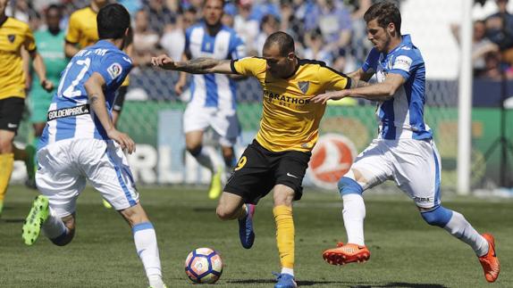 El delantero brasileño del Málaga Charles Dias (c) disputa un balón con los jugadores del Leganés Erik Morán (i) y Rubén Pérez (d).