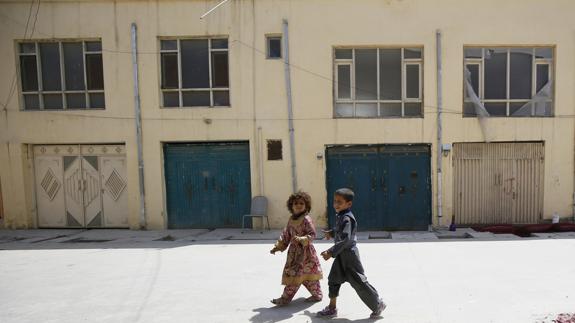 Dos niños pasan junto al lugar del crimen. 