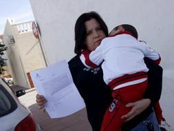 La madre que sufrió el incidente sostiene la denuncia interpuesta con su hijo en los brazos. J. MARTÍN