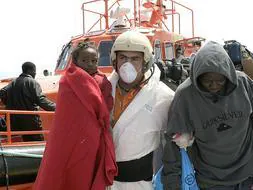Miembros del Servicio Marítimo de la Guardia Civil y voluntarios de Cruz Roja atienden a los inmigrantes. EFE