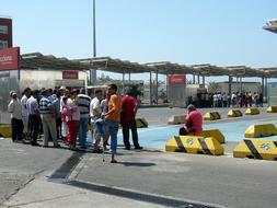 Magrebíes guardan cola para obtener su pasaje de embarque en el Puerto de Almería. / IDEAL