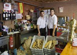 Dos camareros muestran el pan a tirar en un restaurante de Armilla. /A. A.