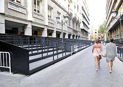 Dos turistas pasean por las recién instaladas tribunas de la calle Ganivet. :: PACO ORTIZ