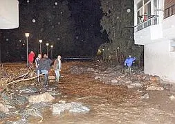 El desbordamiento de la rambla dejó llena de piedras y agua esta calle de Calahonda. :: SALVADOR RODRÍGUEZ
