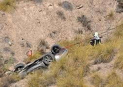 Los bomberos intentan sacar el coche del lugar del siniestro. :: JOSÉ UTRERA