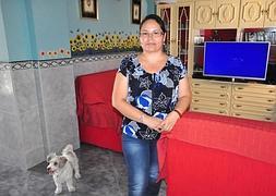 Cintia, en su casa junto a su perro, 'Roky', del que dice que es «el pequeño de la casa». :: CHAPA