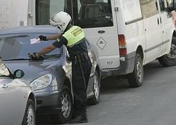 Un agente de la Policía Local de Motril multa a un vehículo, en una imagen de archivo. :: A. A.