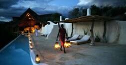 Un camarero masai 'planta' quinqués en la piscina de un 'eco-lodge' de lujo en Shompole, junto a la frontera con Tanzania. / FOTOS: ALFONSO ARMADA