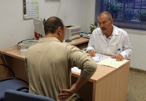 Un trabajador le indica al médico donde tiene su dolor de espaldas. /IDEAL