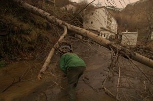 Un lugareño lucha contra una montaña de barro que ha arrastrado los árboles en pleno casco urbano de Trevélez. :: RAFAEL VÍLCHEZ