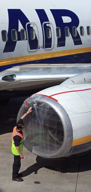 Un trabajador del aeropuerto de Belfast sella con un plástico la turbina de un avión. ::
AFP