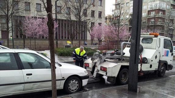 Una grúa municipal retira un vehículo mal aparcado en la capital.