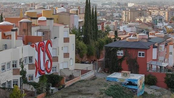 Un 'SOS' gigante pintado en una fachada pide ayuda al Ayuntamiento en El Serrallo. 