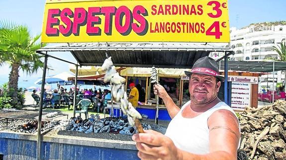 Francisco Javier Ortuño prepara los primeros espetos del día en el chiringuito La Dorada de Plata, en la Playa de San Cristóbal. 