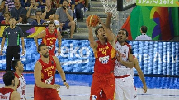 Pau Gasol se dispone a encestar frente a Haddadi ante la atenta mirada de su hermano Marc 