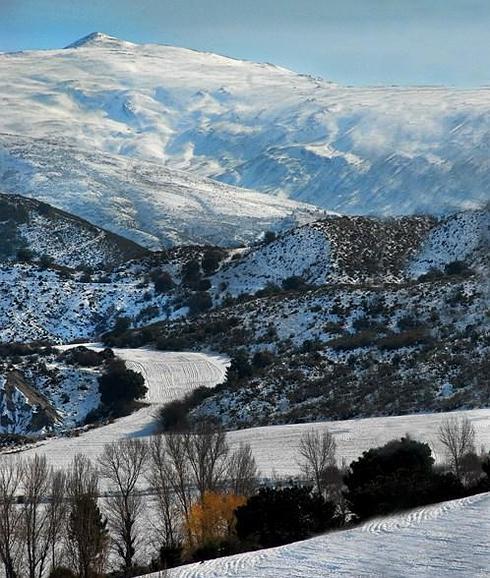 La nieve cubre los cultivos aterrazados y marca los caminos que ascienden desde el Hervidero hacia el interior de la Sierra, con el pico del Caballo, al fondo.