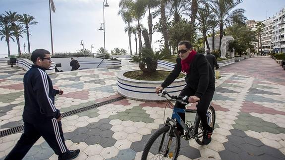 Ciclista y peatón se cruzan en la acera del Paseo del Altillo a la que le ganará terreno la calzada para ampliar su anchura.