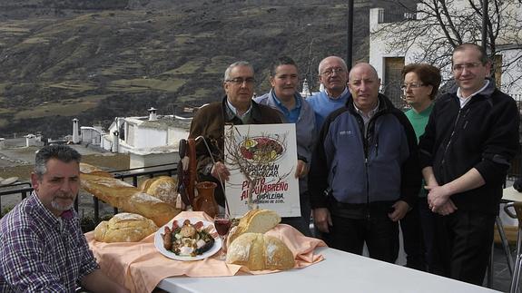 El alcalde, Francisco López, junto a varios propietarios de restaurantes de Capileira con un típico plato alpujarreño.