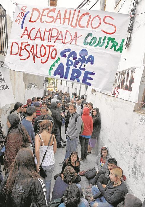 Un grupo de personas forma un muro humano para evitar el desalojo de la 'Casa del Aire'.