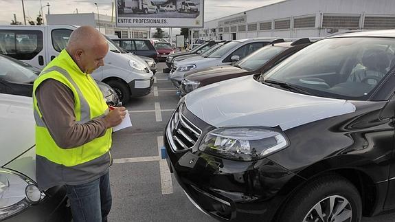 Un técnico anota los datos de un vehículo.