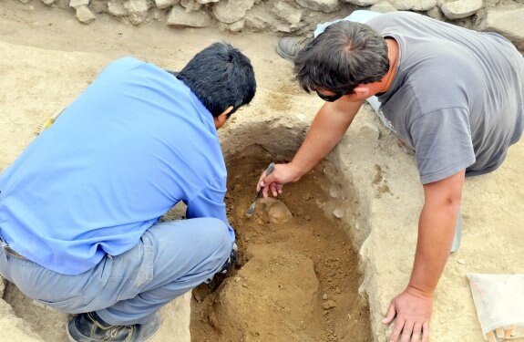 Arqueólogos trabajan en la fosa del joven encontrado.