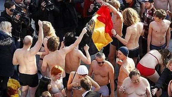 Jóvenes belgas, en Gante, en pleno proceso de 'strip-tease' para protestar por la falta de Gobierno. 
