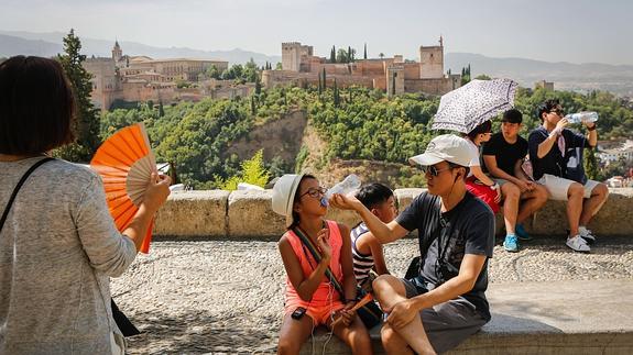 Un grupo de turistas beben agua en el Mirador de San Nicolás para combatir las altas temperaturas.