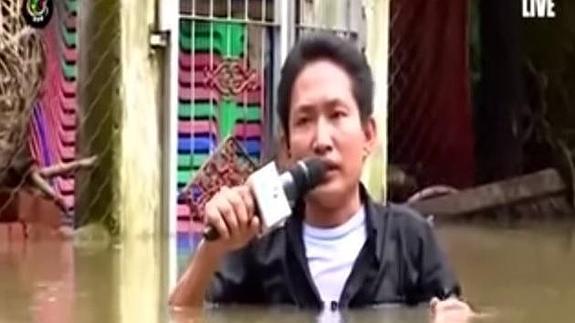 Un reportero se sumerge hasta los hombros para informar de las inundaciones en Myanmar