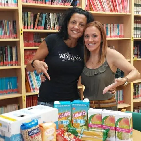 La directora de la biblioteca de Híjar-Las Gabias y autora de esta iniciativa, Ruth Galindo (izquierda), con algunos de los alimentos recaudados
