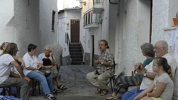 Un grupo de vecinos disfruta de una tertulia en una de las calles de la localidad.