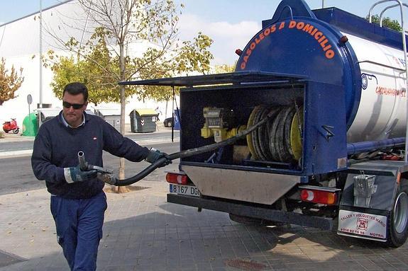 Un operario prepara el suministro de gasóleo C a una comunidad de vecinos de Granada.