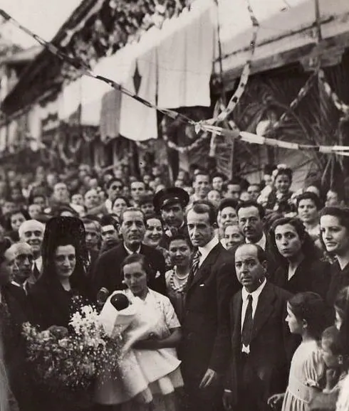 Antonio Gallego Burín, alcalde de Granada, posa junto a los vecinos del Albaicín en la Casa de la Lona tras el bautizo de una niña abandonada en el barrio y que el alcalde y su mujer apadrinaron. Mayo de 1944 .