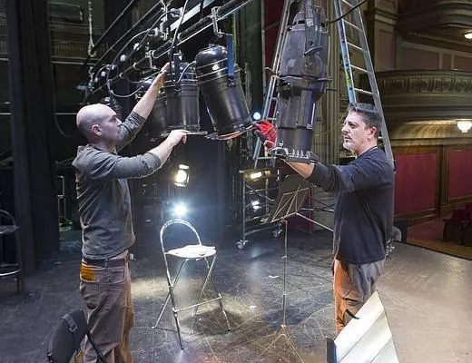 Eloy Merino y Ramón Álvarez, iluminadores del teatro Isabel la Católica, colocan las luces en el escenario.