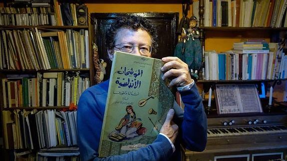 Reynaldo Fernández, en su casa del Albayzín, con un libro de partituras en árabe.  