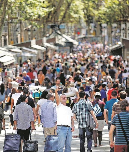 Un turista se hace un selfi en Las Ramblas de Barcelona, donde Ada Colau intenta poner freno al crecimiento de los alojamientos turísticos.